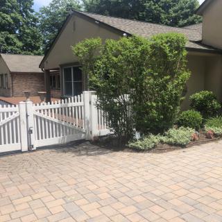A residential house with a white picket fence and well-maintained landscaping.
