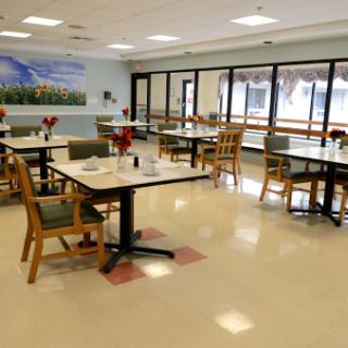 A spacious and well-lit dining area featuring neatly arranged tables and chairs, ready for patrons.