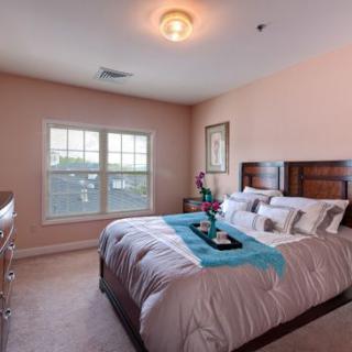 A cozy bedroom with a neatly made bed and natural light from the window.