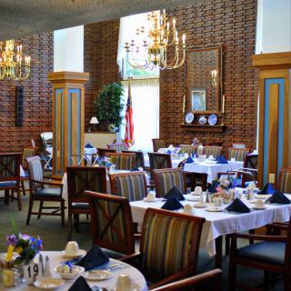 An elegant dining room with beautifully set tables and chandeliers.