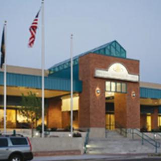 A building with a brick facade and multiple flags displayed in front.