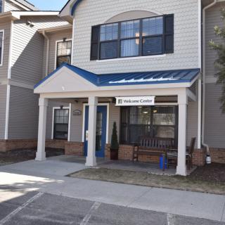 The entrance to a residential apartment building with a covered porch.