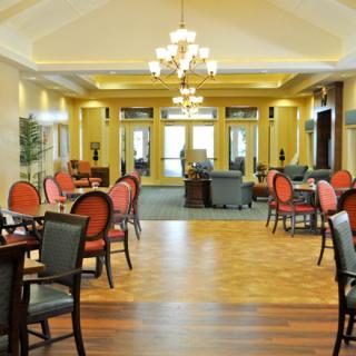 Elegant dining area with polished wooden floors and classic chandeliers.