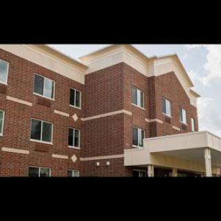 A modern brick building featuring multiple windows and a welcoming entrance.