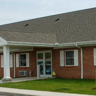 A one-story brick commercial building with a main entrance and several windows.