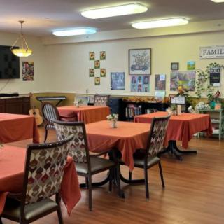 An indoor dining room with several tables and chairs, featuring decorative elements on the walls.
