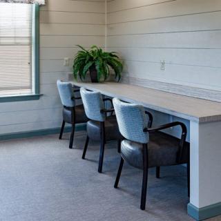 A clean and organized office workspace with chairs, a desk, and a plant.