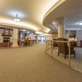 A spacious lobby interior featuring elegant columns, comfortable seating, and warm lighting.
