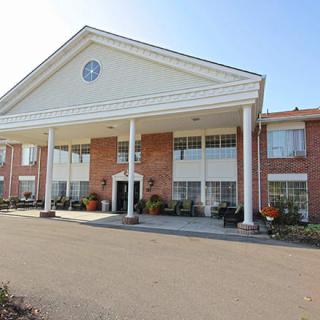 A two-story building with large white columns and a brick facade.
