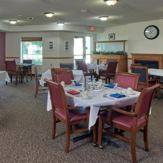An empty dining room with neatly arranged tables and chairs, prepared for guests.