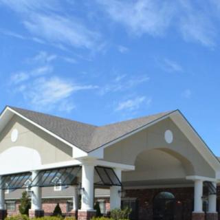 A modern building with a prominent entrance and columns under a clear blue sky.