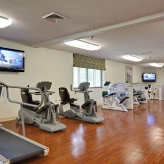 A well-equipped gym featuring various exercise machines and televisions for an engaging workout experience.