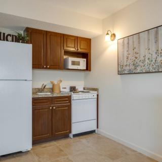 A small apartment kitchen featuring a refrigerator, microwave, and stove with wooden cabinets and modern decor.