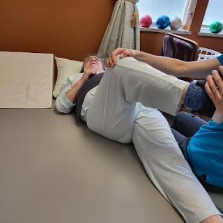 A physical therapist assists a patient with leg exercises during a rehabilitation session.
