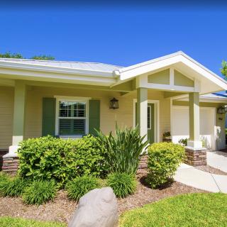 A charming residential house with landscaped front yard on a sunny day.