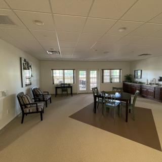 A spacious interior with a dining area featuring a table and chairs, large windows, and additional seating.