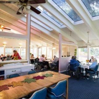 A bright restaurant interior with skylights and patrons dining.