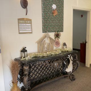 A beautifully styled entryway featuring an ornate console table and decorative wall art.