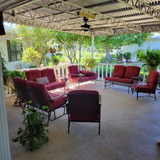 A cozy outdoor patio area with comfortable seating and lush greenery.