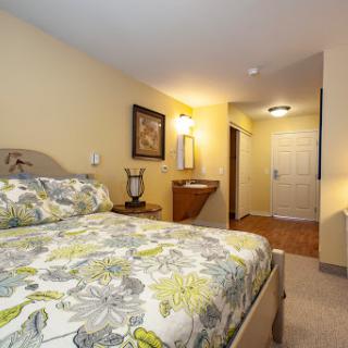 A cozy and inviting bedroom featuring floral bedding and warm lighting.
