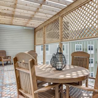 A serene outdoor patio featuring wooden furniture and latticework, perfect for dining and relaxation.