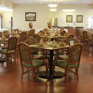 An empty dining area in a restaurant with neatly arranged tables and chairs.