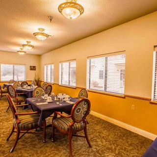 A well-lit dining room with elegantly arranged tables and chairs in a cozy setting.