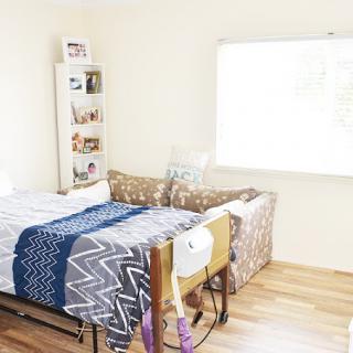 A minimalist bedroom with a neatly arranged bed and a bright window.