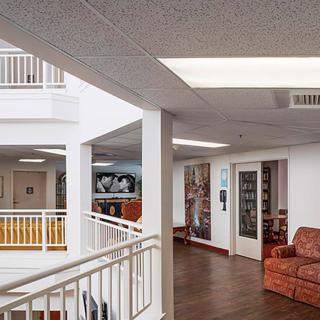 A spacious interior hallway with artwork, a seating area, and a balcony.