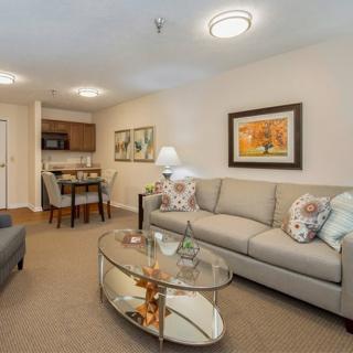 A cozy living room with comfortable seating, a glass coffee table, and tasteful decor.