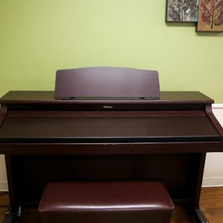 A stylish piano setup against a vibrant green wall.