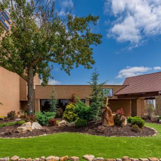 A landscaped garden with a building and clear blue sky.