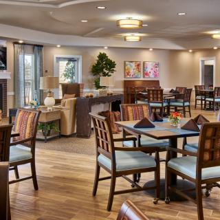A modern dining area with neatly arranged tables and chairs, featuring contemporary decor and lighting.
