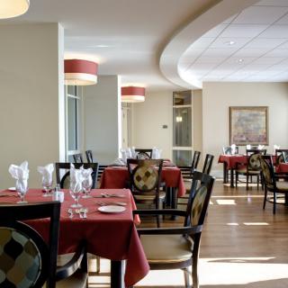 A well-set dining area in a restaurant with red tablecloths and elegant decor.