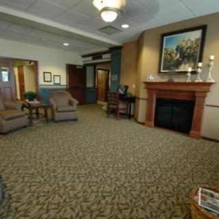 A cozy lobby with a seating area, featuring comfortable chairs and a fireplace.