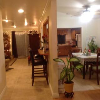 A cozy home interior featuring a kitchen and dining area with plants and warm lighting.