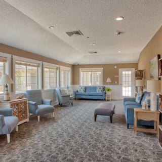 A spacious and well-lit living room with comfortable seating and large windows.