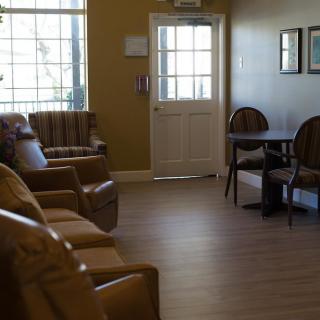 An interior view of a waiting room with chairs lined up against the wall.