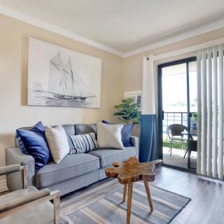 A cozy living room with modern decor, featuring a gray sofa, wooden coffee table, and a scenic balcony view.