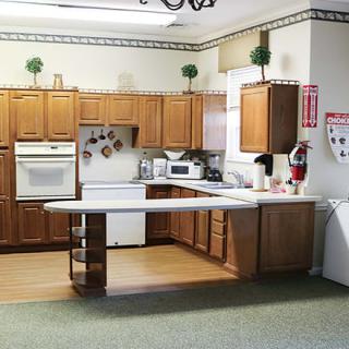 A kitchen with wooden cabinets, appliances, and a countertop.