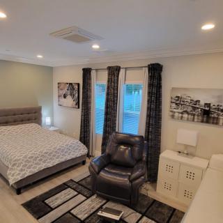 A cozy bedroom with a bed, armchair, and contemporary decor.