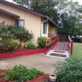 A house with a red ramp and landscaped yard.