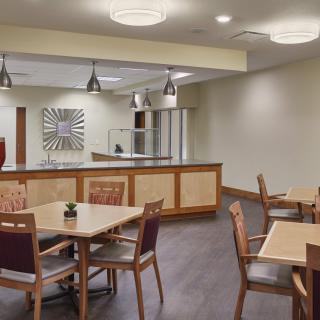 A modern, well-lit dining area with tables and chairs.