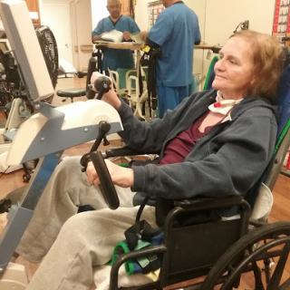 A patient engaged in rehabilitation exercises while seated in a wheelchair.
