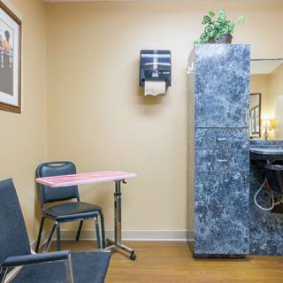 A small waiting area in a medical office with chairs, a table, and a cabinet.