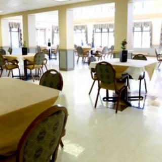 A bright dining room with neatly arranged tables and chairs.