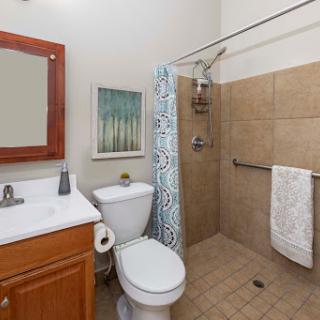 A compact and aesthetically pleasing bathroom featuring a shower, toilet, and vanity sink.