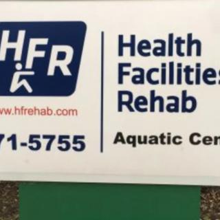 Sign for Health Facilities Rehab Aquatic Center with contact details.