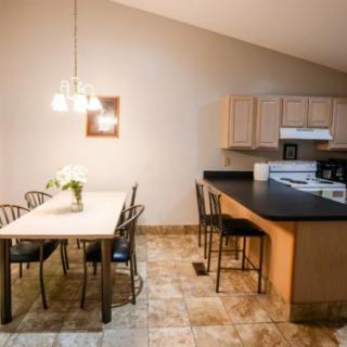 A cozy kitchen and dining area with a table, chairs, and modern appliances.