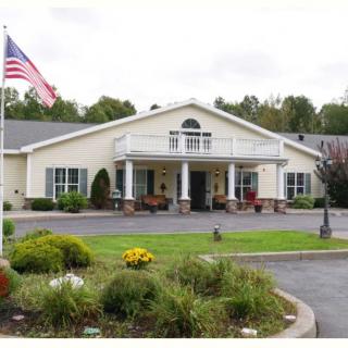 A building with an American flag and a landscaped garden in front.